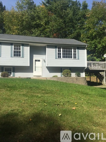 A house with a white door and two windows is for sale.