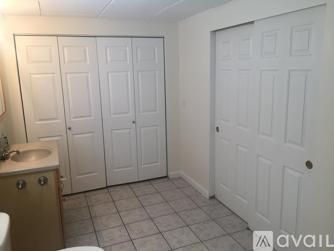 A bathroom with a sink, toilet, and two white doors.