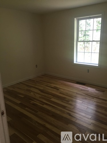 A room with wooden flooring and a window.