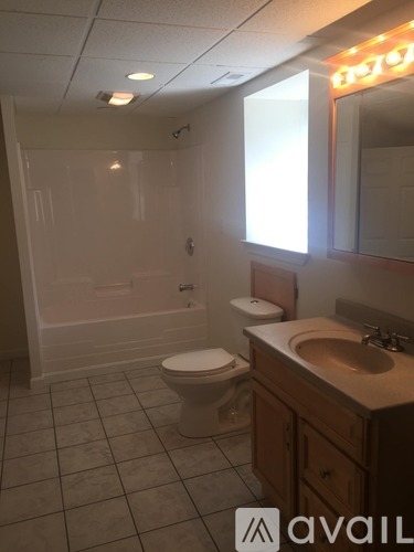 A bathroom with a toilet, sink, and mirror.