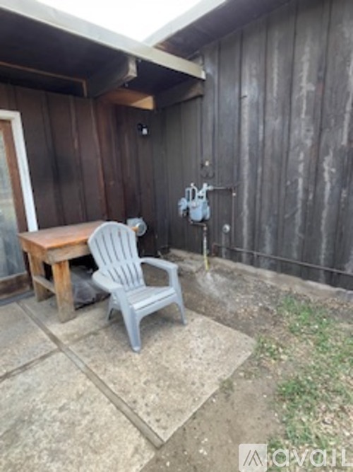 A grey plastic chair is on a patio.
