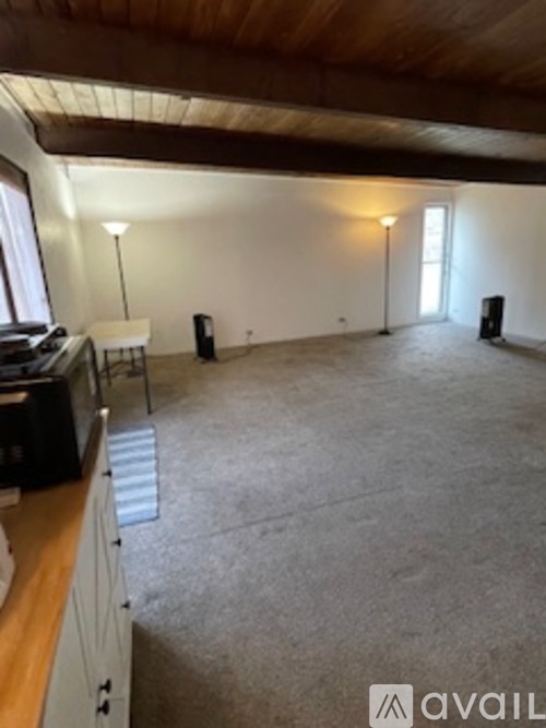 A room with a wooden ceiling and carpeted floor.