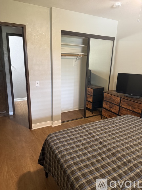 A bedroom with a bed, dresser, and mirror.