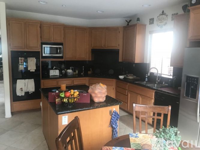 A kitchen with wooden cabinets and black countertops.