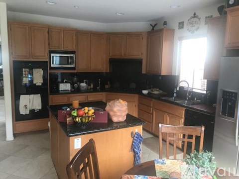 A kitchen with wooden cabinets and black countertops.