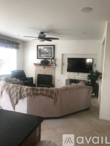 A living room with a couch, a fireplace, and a television.