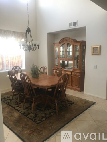 A dining room with a wooden table and chairs.