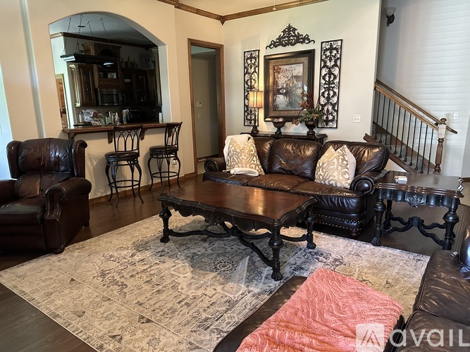 A living room with a brown leather couch and a wooden coffee table.
