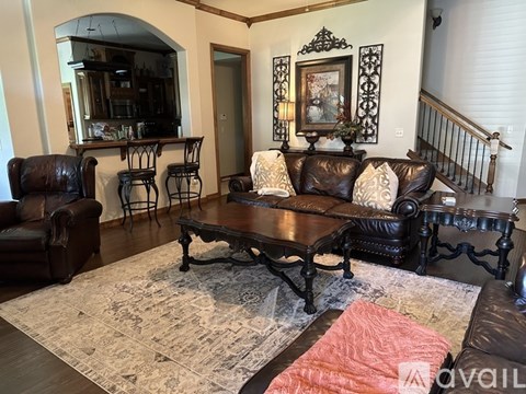 A living room with a brown leather couch and a wooden coffee table.