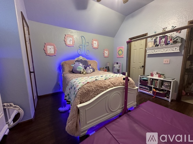 A bedroom with a bed, a purple mattress, and a white bed frame.