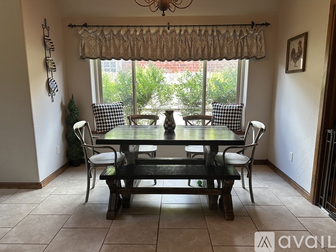 A dining room with a table and chairs.