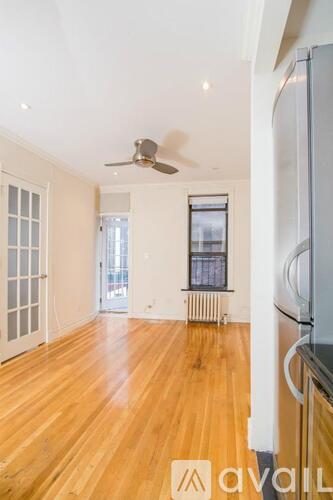 A room with wooden floors and a ceiling fan.