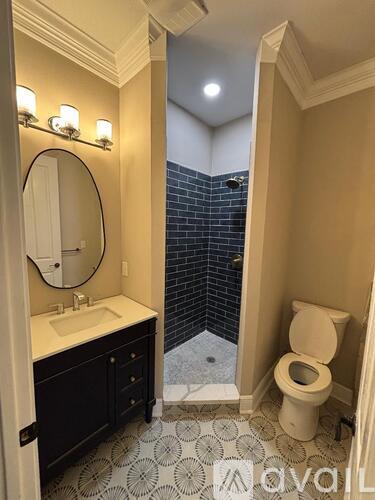 A bathroom with a toilet, sink, and a mirror.