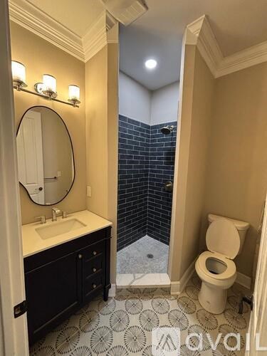 A bathroom with a toilet, sink, and a mirror.