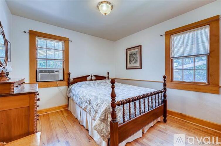 A bedroom with a four poster bed and wooden floors.