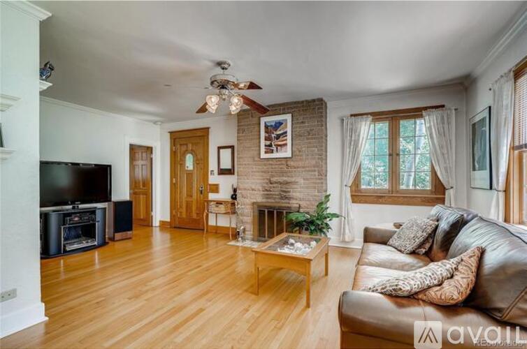 A living room with a brown leather couch and a wooden coffee table.