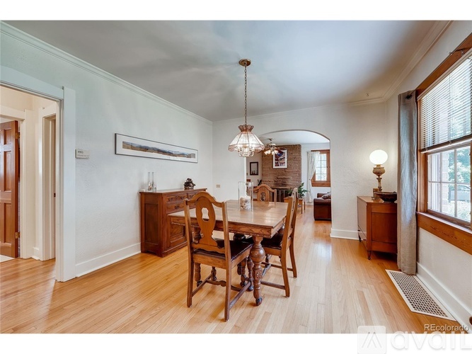 A dining room with a wooden table and chairs.
