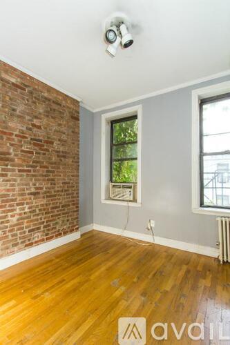 A room with a brick wall and wooden flooring.