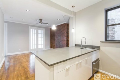 A kitchen with a wooden floor and white cabinets.