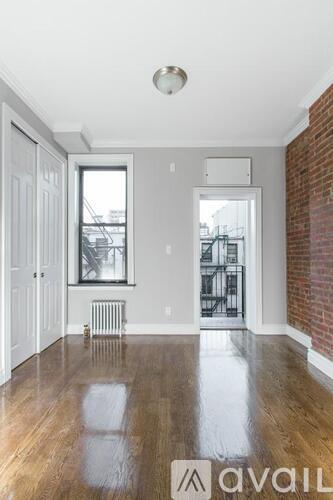 A room with a wooden floor and a brick wall.