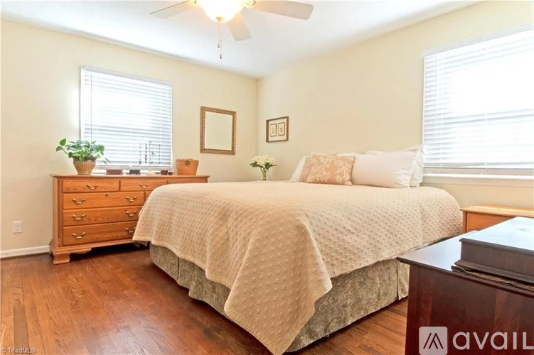 A bedroom with a bed, dresser, and ceiling fan.