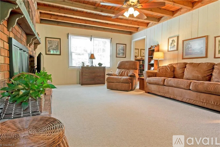 A living room with a brown couch, a chair, and a table.
