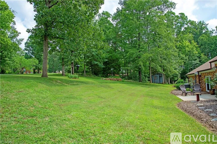 A grassy area with trees and a building in the background.