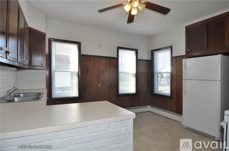 A kitchen with a white counter top and a ceiling fan.