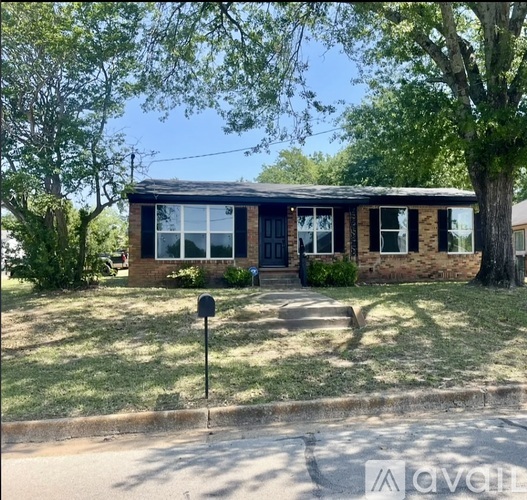 A house with a black roof and a mailbox in front.