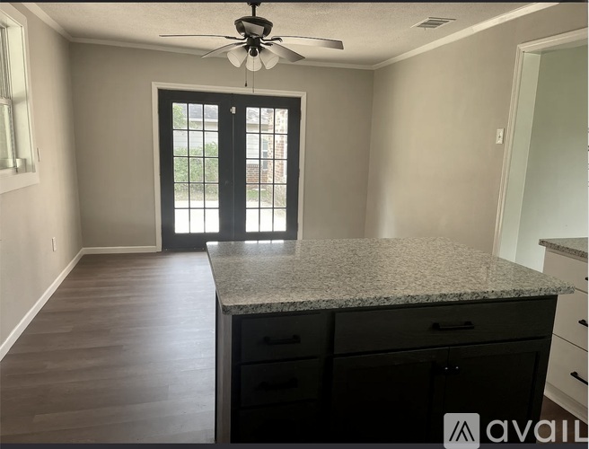 A room with a fan, a window, and a countertop.