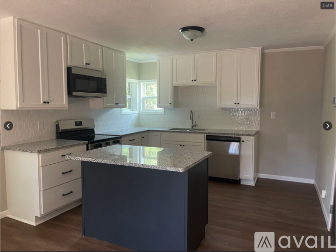 A kitchen with a granite countertop and white cabinets.