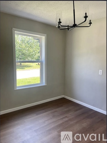 A room with a window and a chandelier.