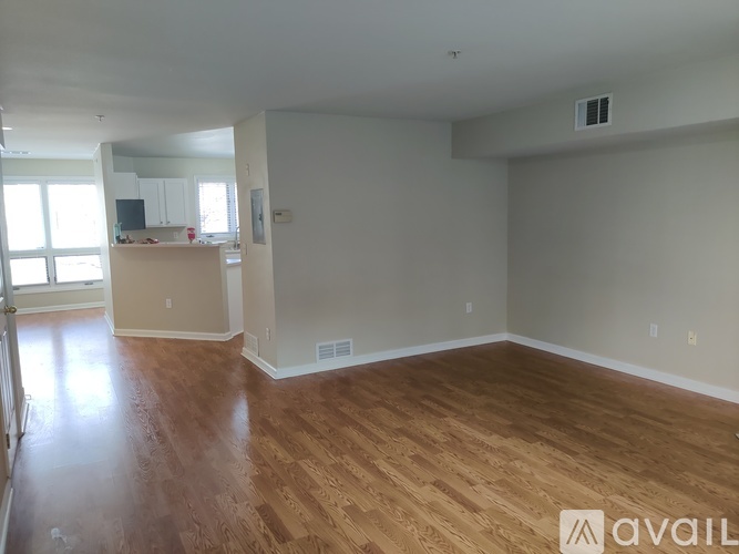 A room with wooden flooring and white walls is available for rent.
