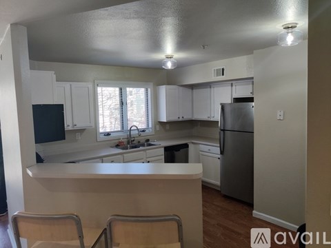 A kitchen with white cabinets and a refrigerator.