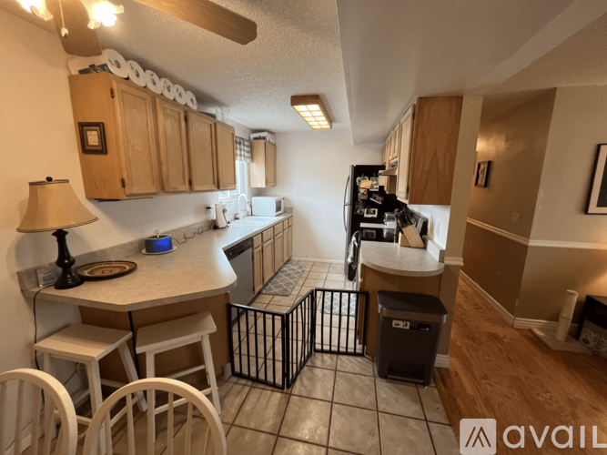 A kitchen with a table and chairs in the foreground and a refrigerator in the background.