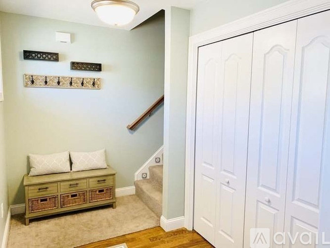 A hallway with a bench and a staircase.