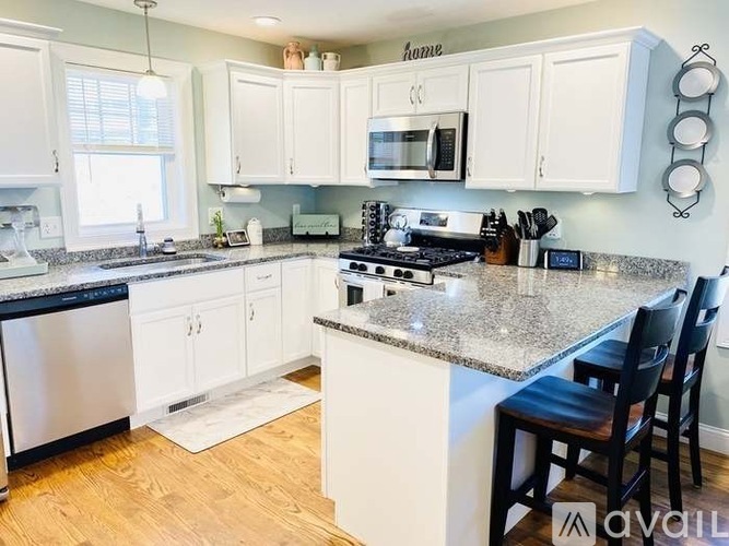 A kitchen with white cabinets and a granite countertop.