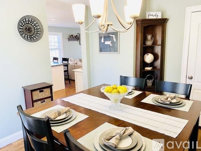 A dining room with a wooden table set for a meal.