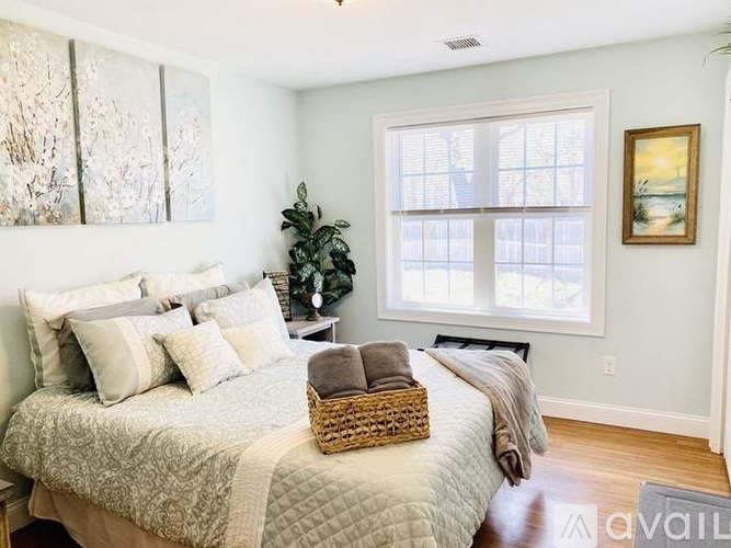 A bedroom with a large bed and a painting on the wall.