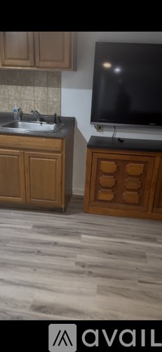 A kitchen with wooden cabinets and a black television.