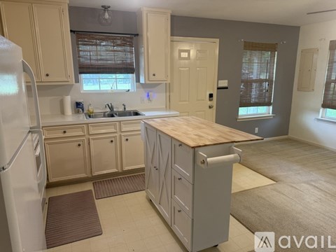 A kitchen with a refrigerator, sink, and cabinets.