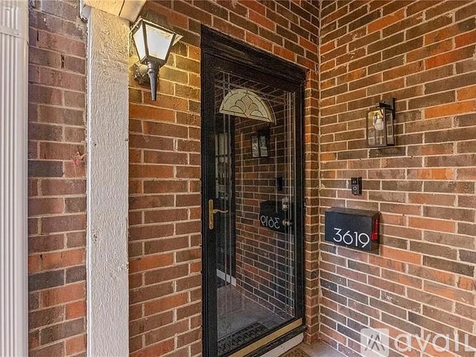 A black door with a glass window and a number 3619 on the wall.