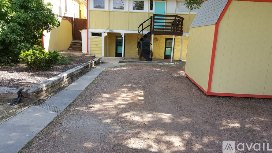 A yellow building with a red stripe and a small entrance with a staircase.
