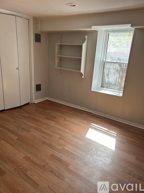 A room with a wooden floor and a window.