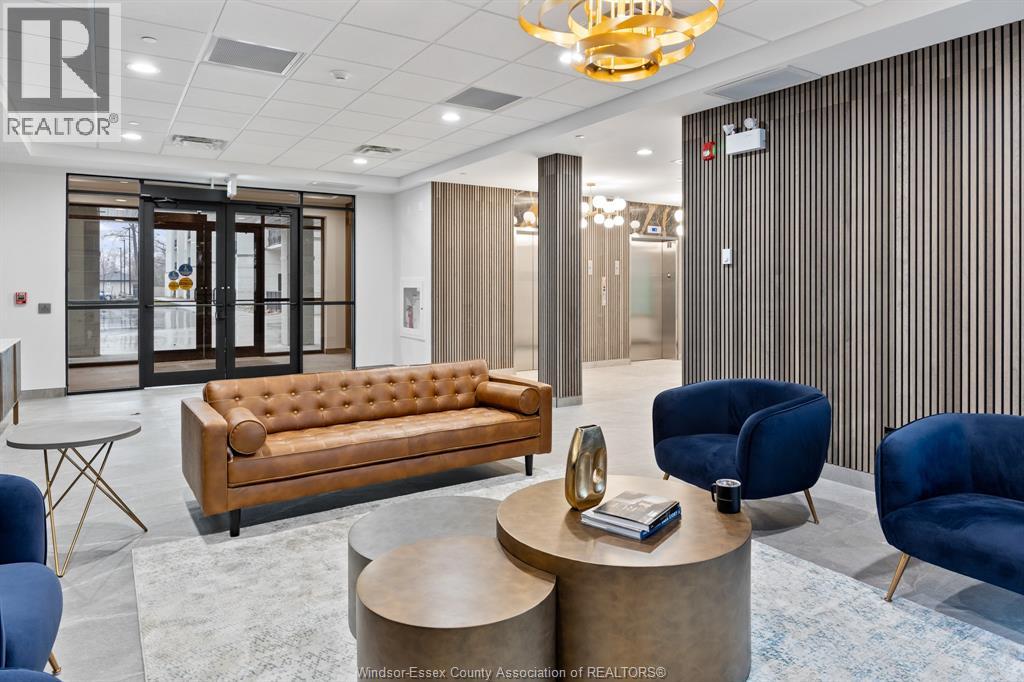 A modern office space with a leather sofa, blue armchairs, and a wooden coffee table.