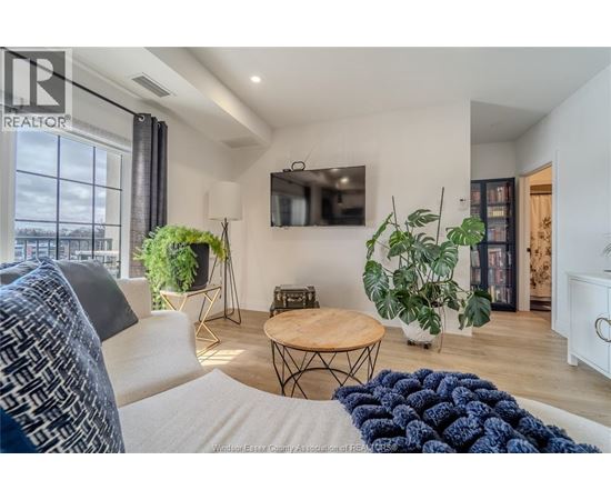 A living room with a white couch and a wooden coffee table.
