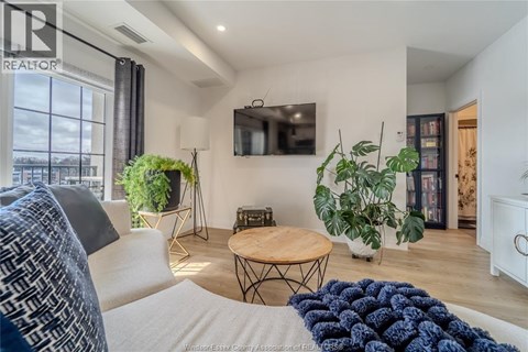 A living room with a white couch and a wooden coffee table.