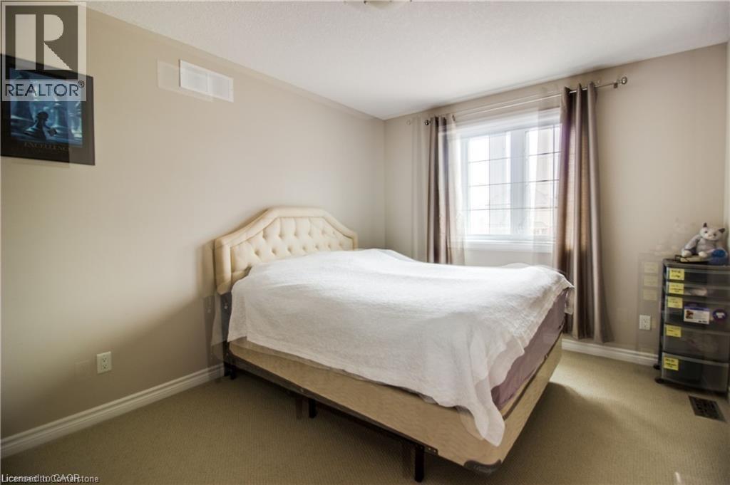 A bedroom with a large bed and a window with curtains.