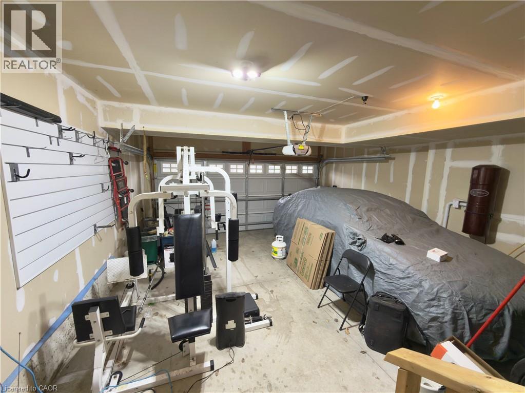 A gym with a weight bench, a barbell and a punching bag.