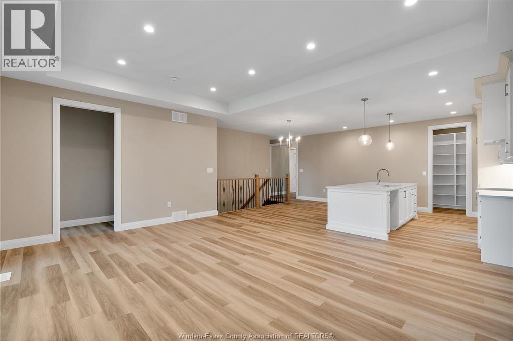 A spacious room with wooden flooring and a white cabinet in the corner.